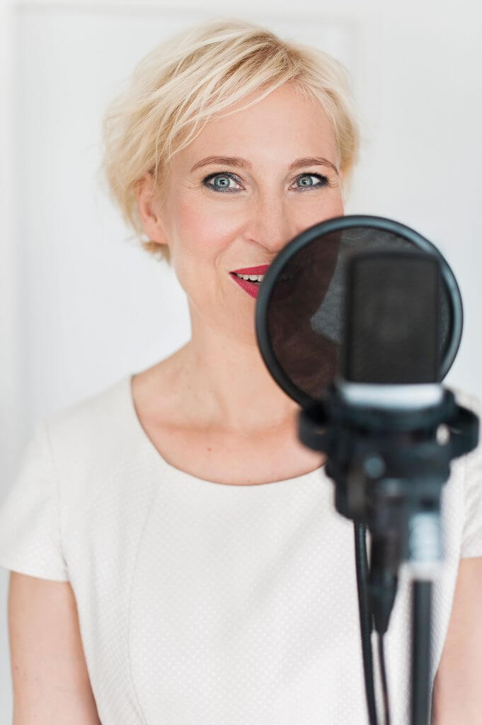 Katrin Friedel Botschafterin für Glück spricht in Mikrofon für Podcast