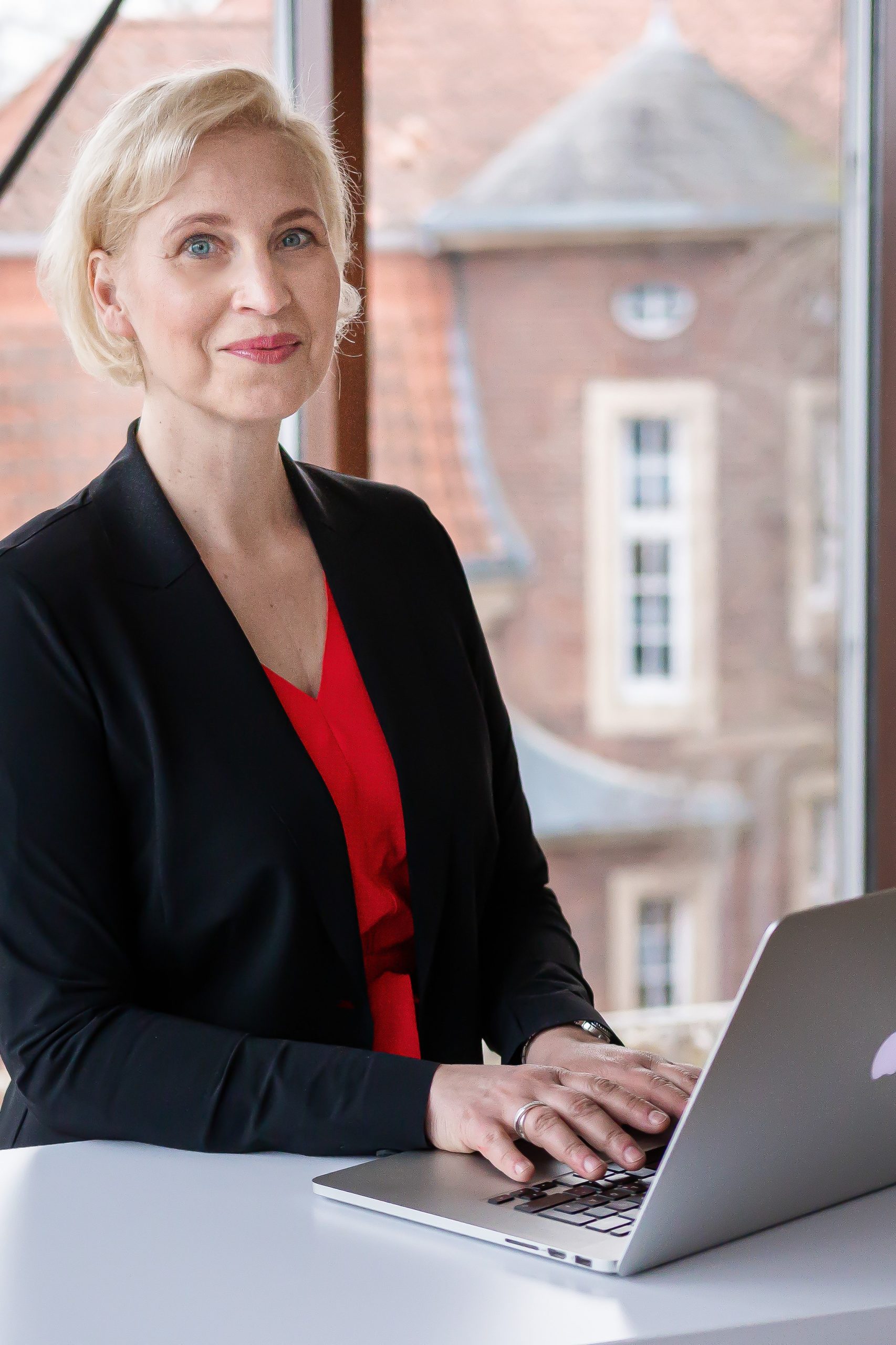 Katrin Friedel am Stehpult mit Laptop_Hochformat